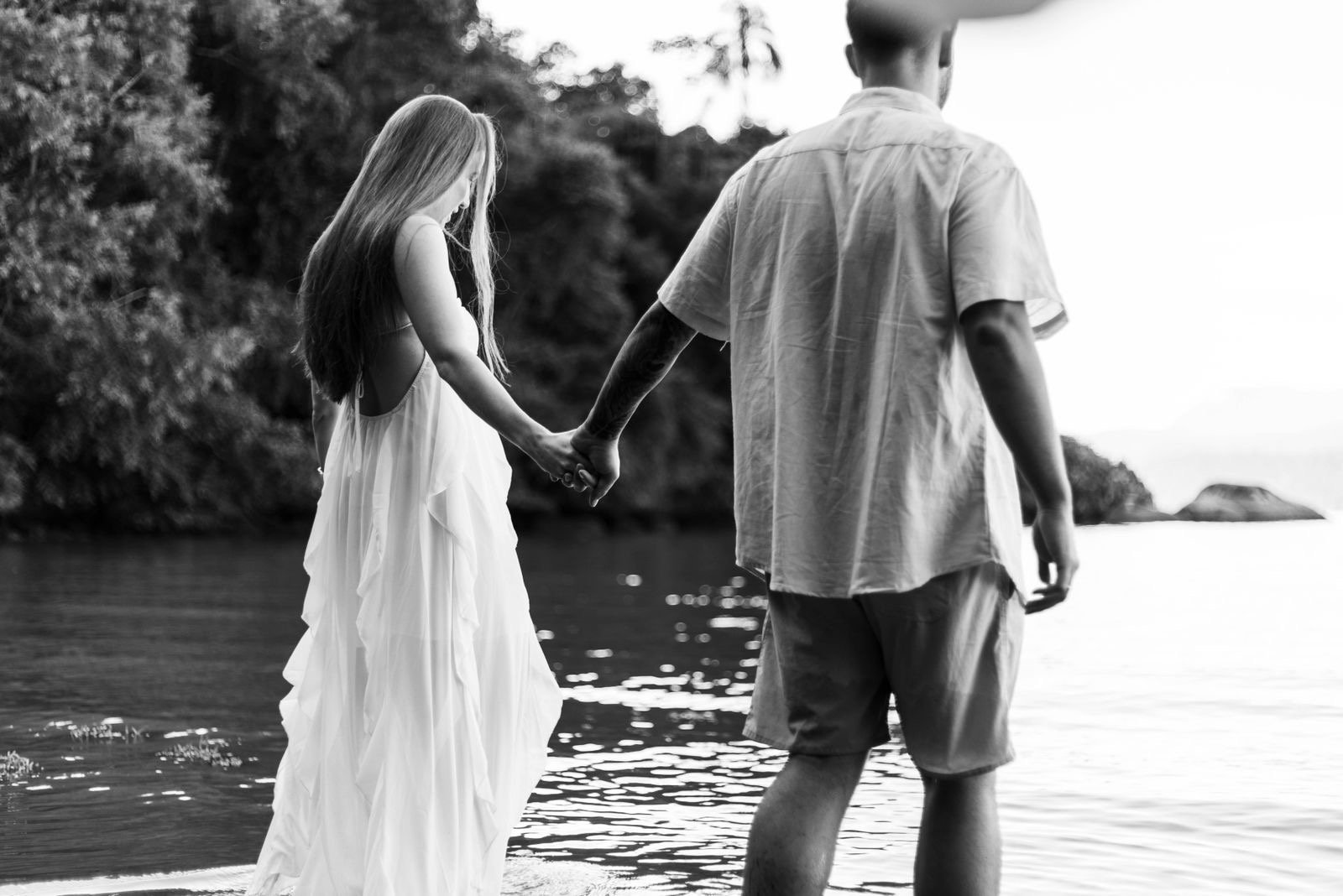 Casal de mãos dadas à beira-mar